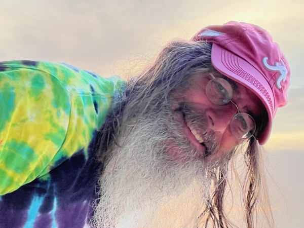 Portrait of David Cutler, CPA wearing an Atlanta Braves hat and a tie dye t shirt.