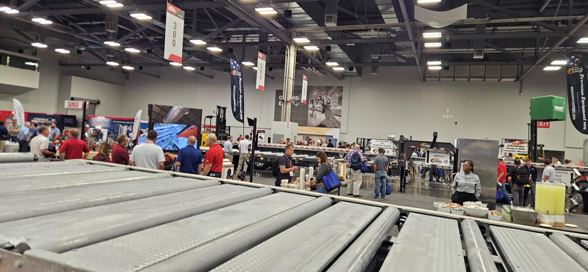 Roller conveyor and flatbed trailers in the equipment hall at BCMC 2026