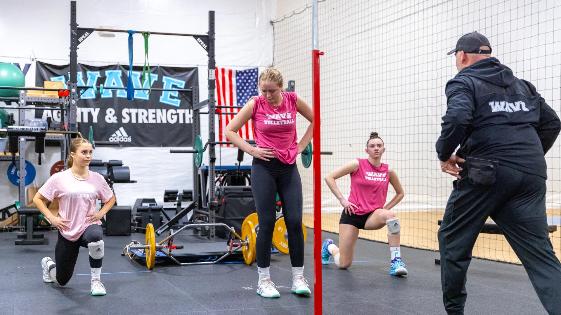 A group of women performing squats in a gym during a 60-minute class at Volley Strong Inc, Del Mar, CA.