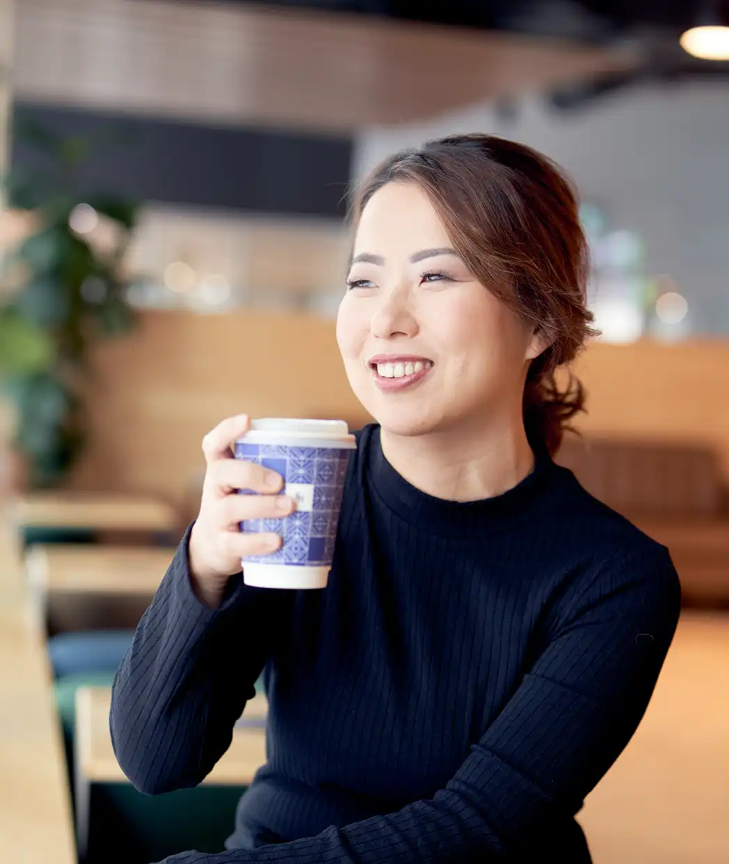 Candid portrait of Liz Choi in conversation at a coffee shop, reflecting her approachable executive advisory style.