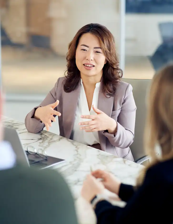 Executive advisor speaking during a small meeting, reflecting strategic guidance, leadership clarity, and collaborative decision-making.