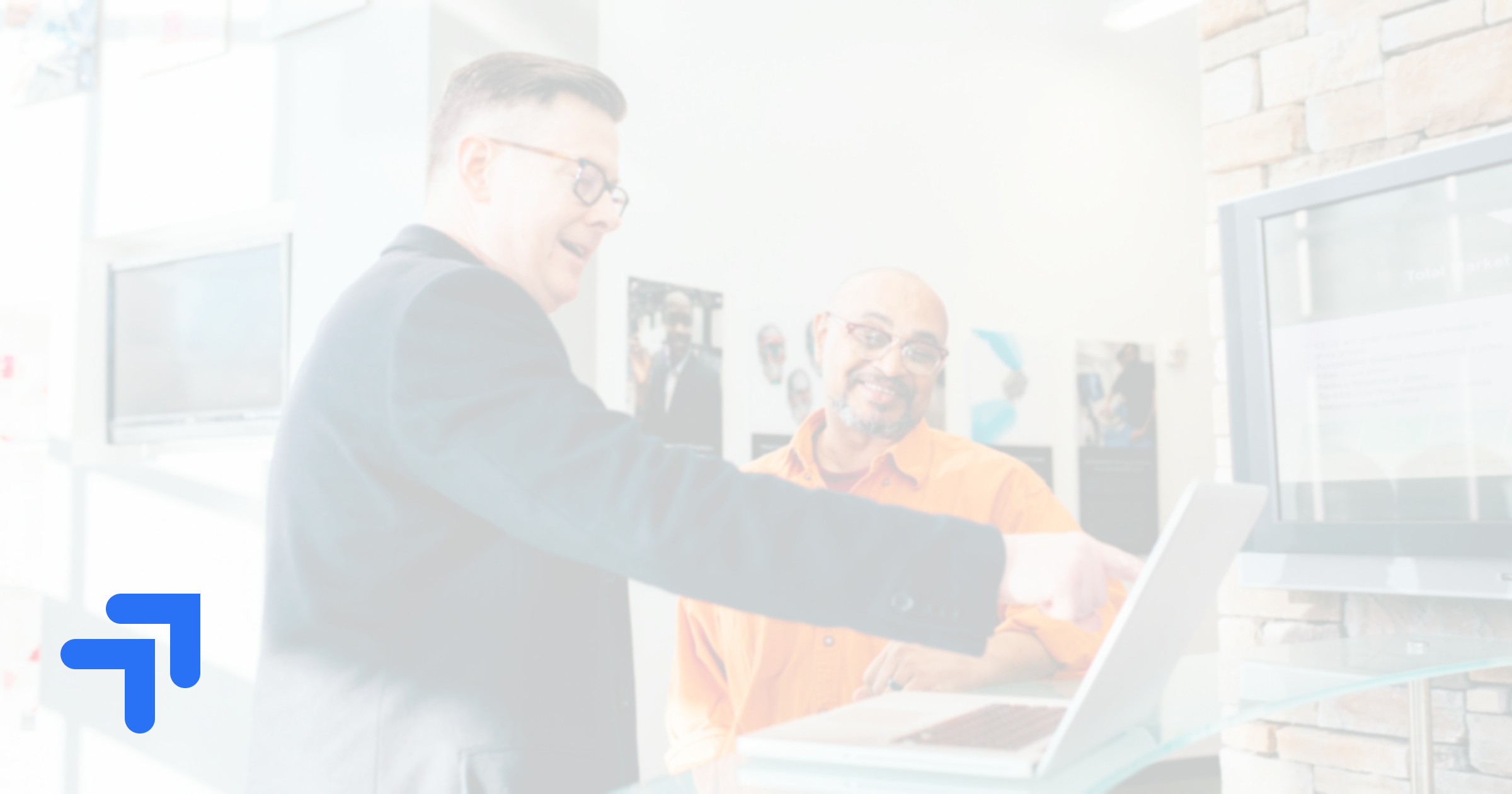 Two sales professionals reviewing AI sales roleplay software on a laptop in a modern office