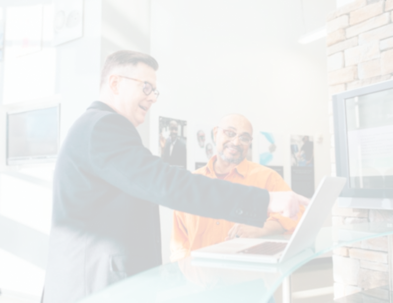 Two sales professionals reviewing AI sales roleplay software on a laptop in a modern office