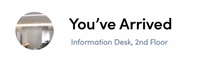 Sign reading 'You’ve Arrived' with text below saying 'Information Desk, 2nd Floor' and a blurred background image of an information area.