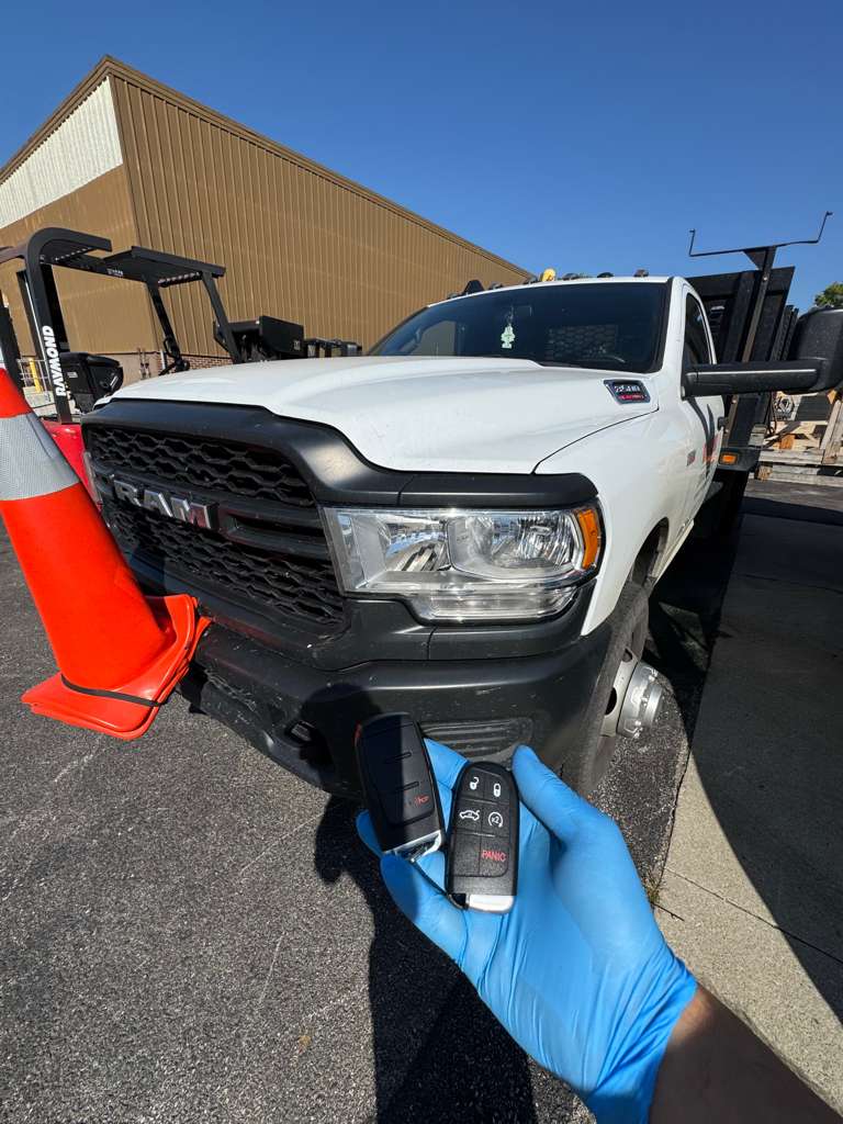 Technician holding new key fobs for a RAM truck