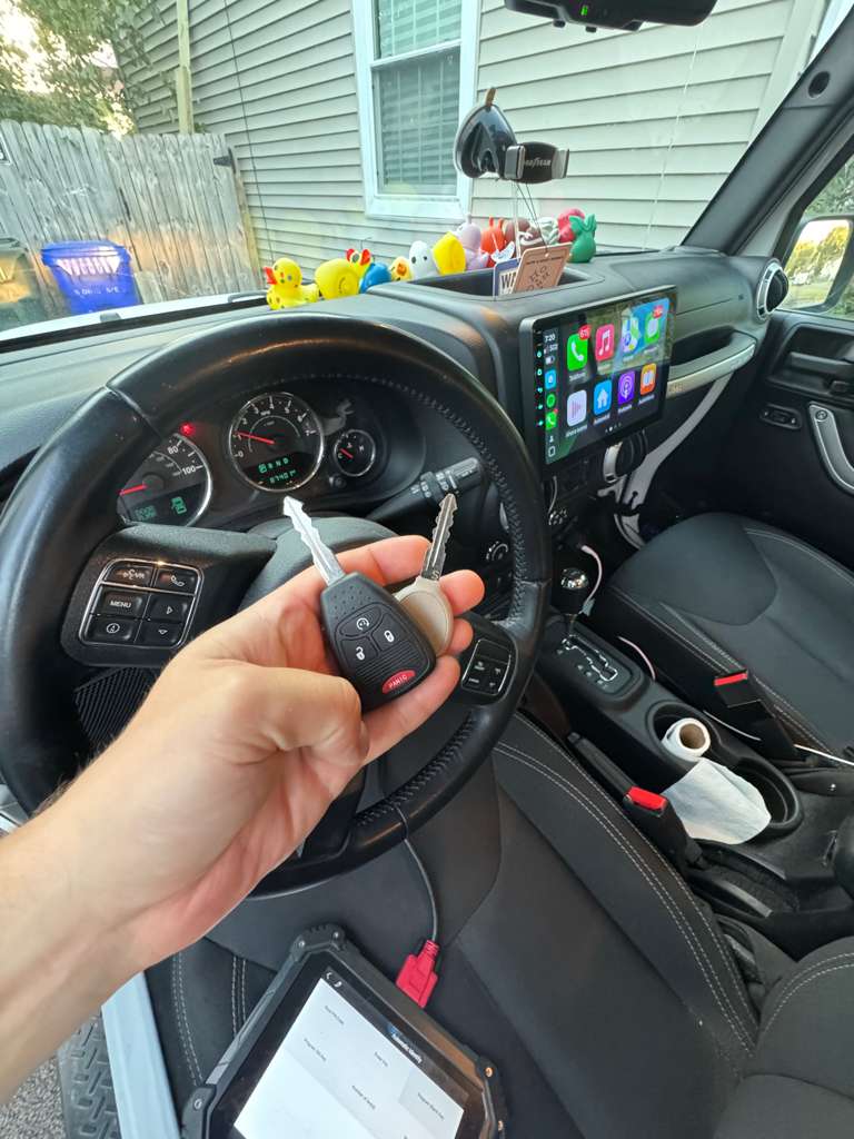 Hand holding programmed Jeep car keys inside vehicle