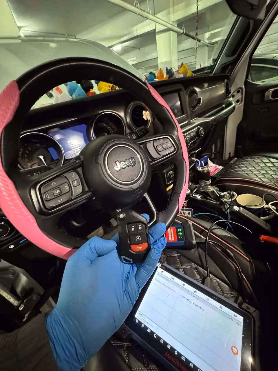 Auto locksmith programming a key fob inside a Jeep in Columbus, OH.