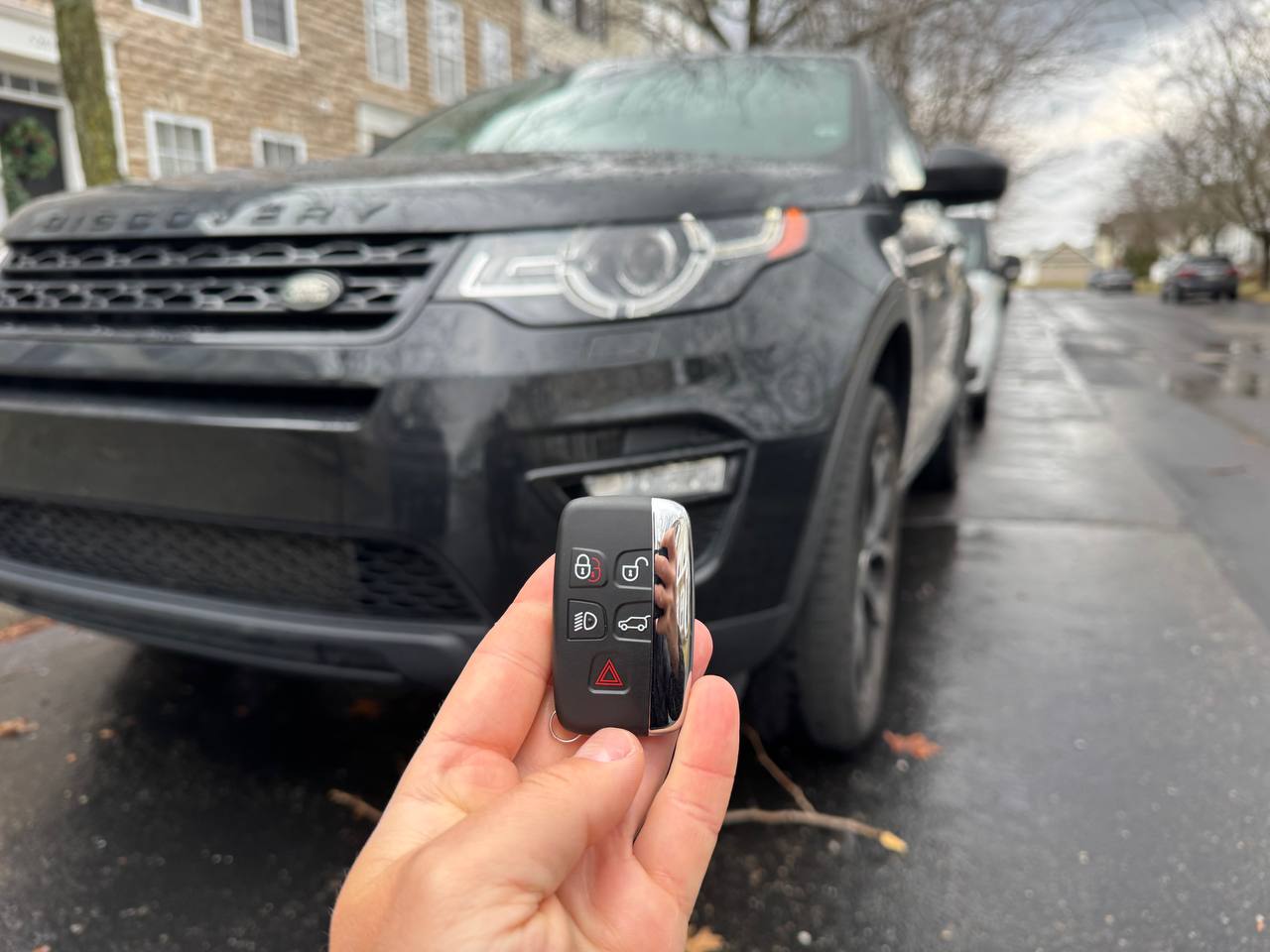 Mobile locksmith programming a Land Rover key fob in Gahanna, Ohio near a parked SUV
