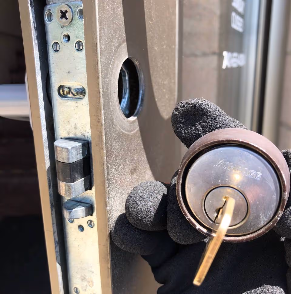 Locksmith rekeying a door lock cylinder on-site