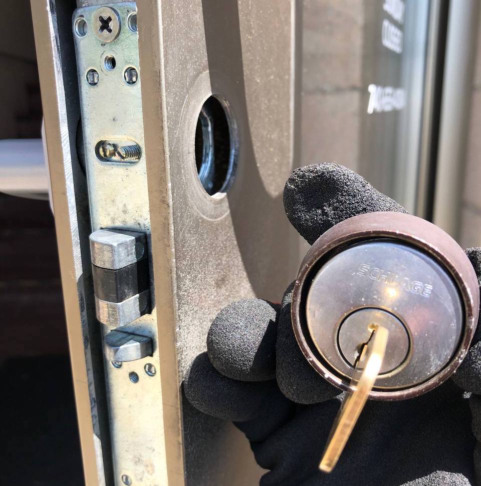 Locksmith rekeying a door lock cylinder on-site