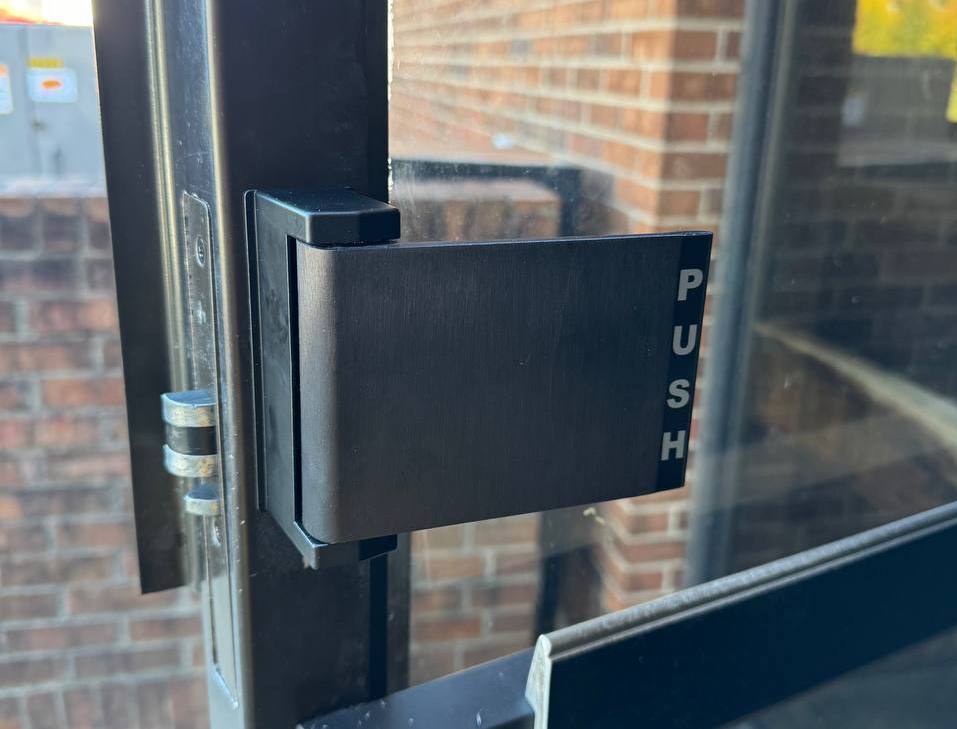 Commercial glass door push bar lock close-up after business lock rekeying