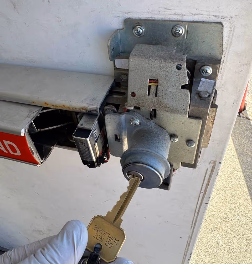 Locksmith rekeying a commercial door lock cylinder with new key for access control reset