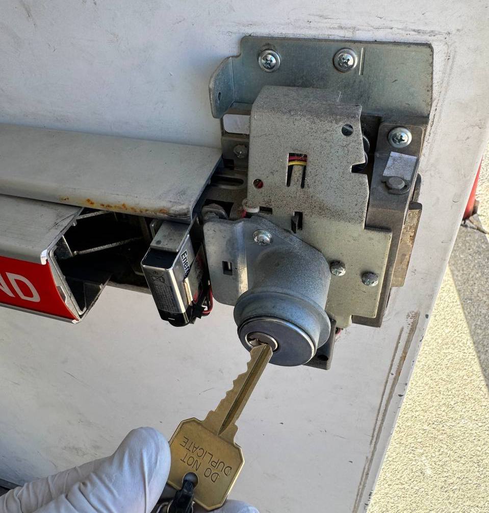 Locksmith rekeying a commercial door lock cylinder with new key for access control reset