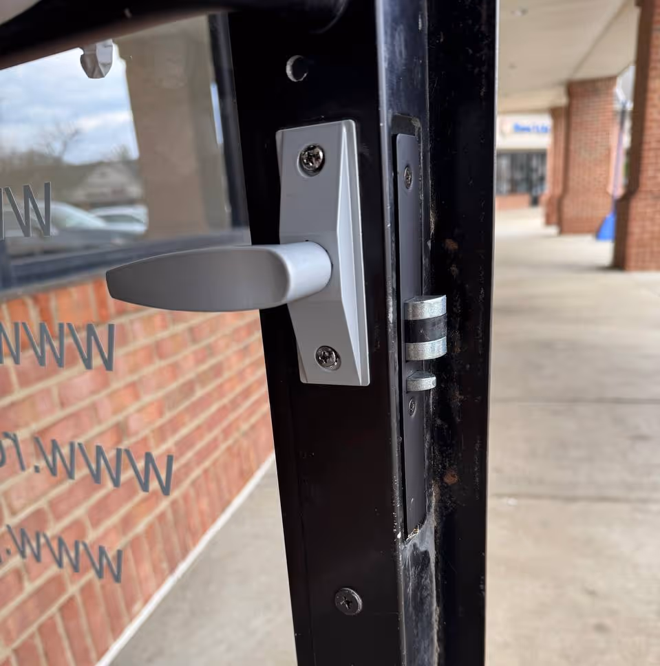 Storefront aluminum door handle and latch showing rekeyed commercial lock hardware