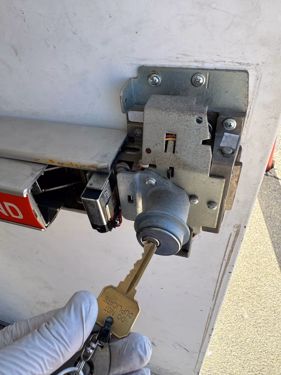 Locksmith servicing panic bar exit device mechanism and cylinder on commercial door