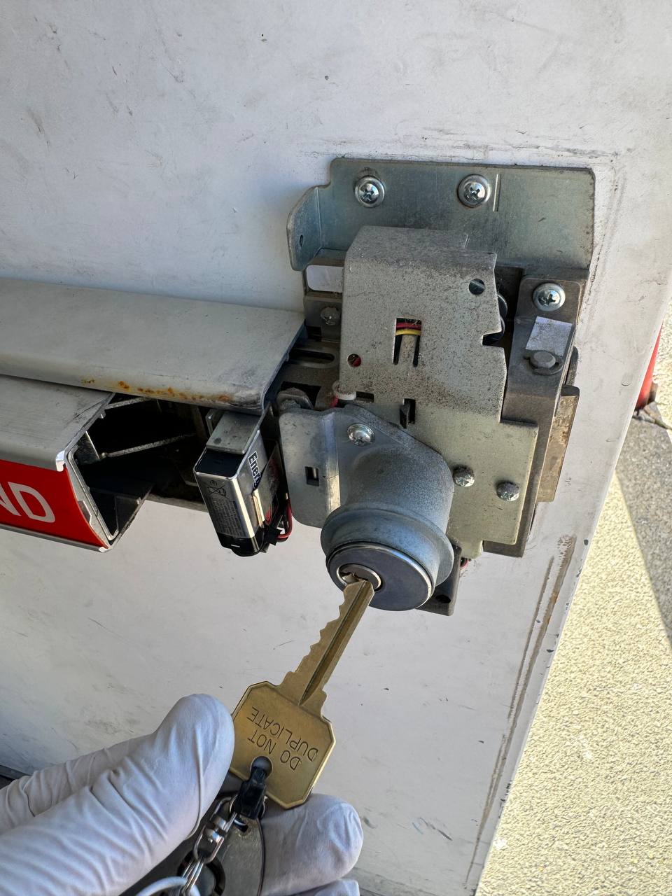 Locksmith servicing panic bar exit device mechanism and cylinder on commercial door