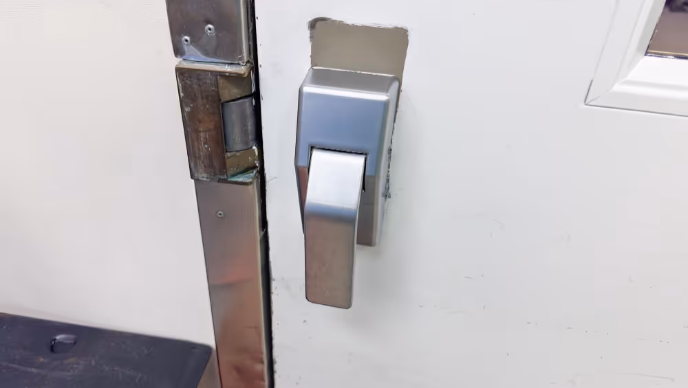 Close-up of commercial door latch and exit device trim after panic bar repair