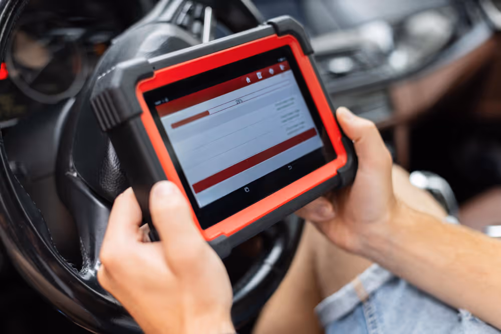 Mechanic using a digital diagnostic scanner to check car systems