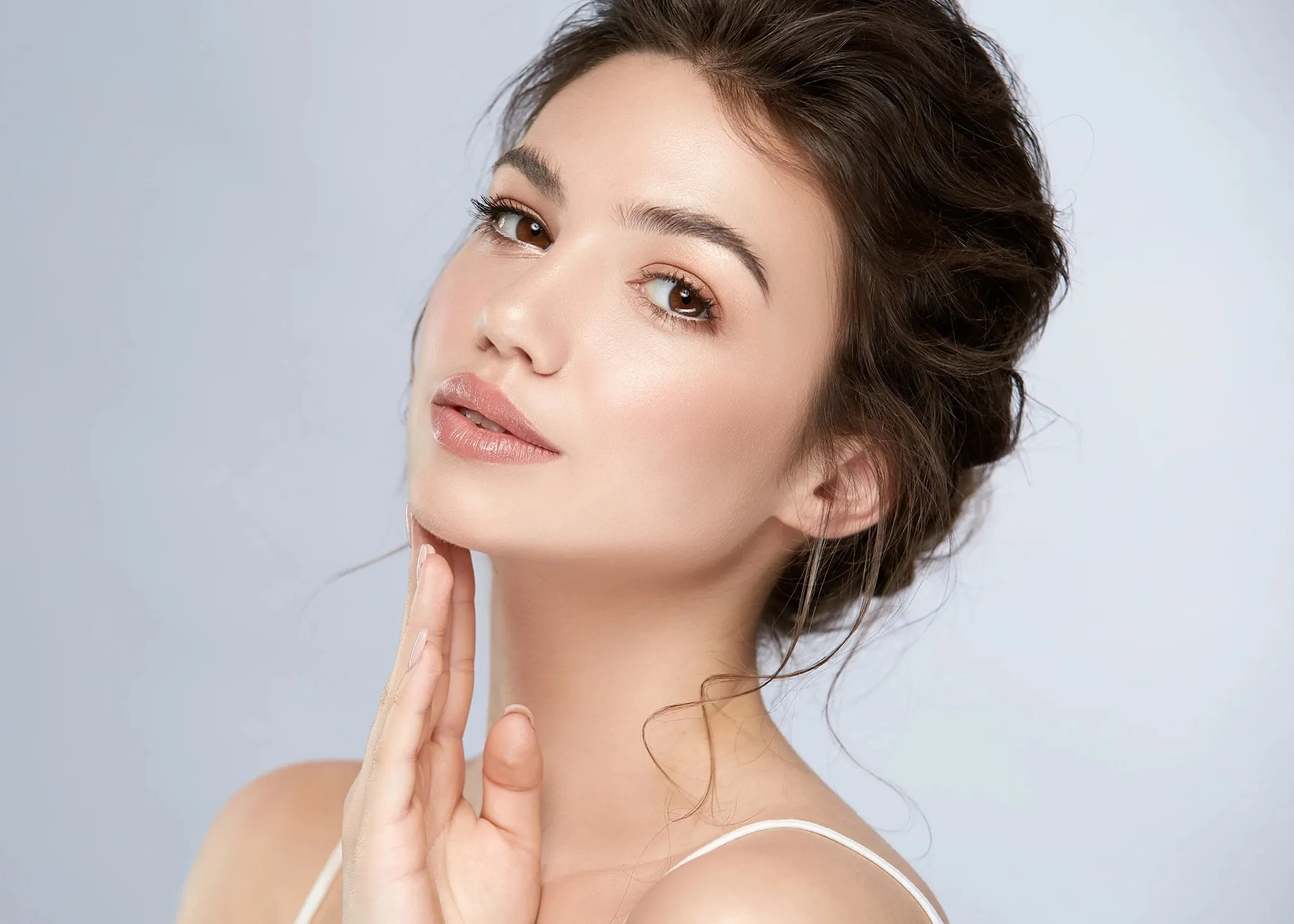 A woman is posing for a picture with her hand on her face.
