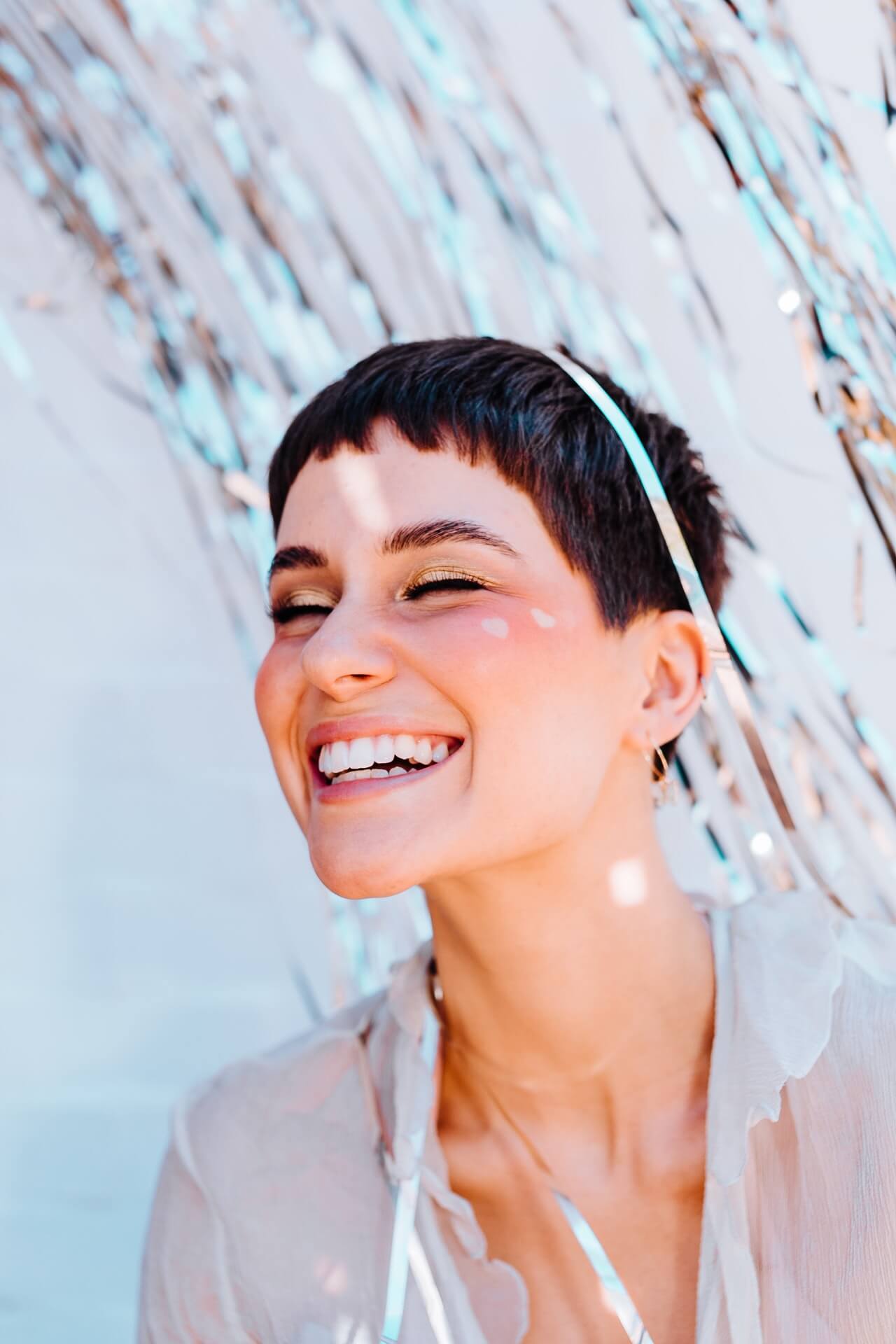 A close up profile photo of a smiling girls with a short hair.