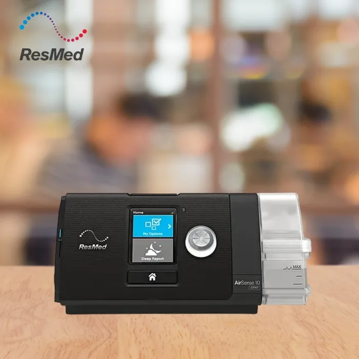 ResMed AirSense 10 AutoSet CPAP machine in black with humidifier, on a wooden table, for sleep apnea therapy

