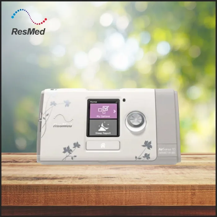 ResMed AirSense 10 AutoSet for Her CPAP machine with floral design on wooden table, for sleep apnea therapy

