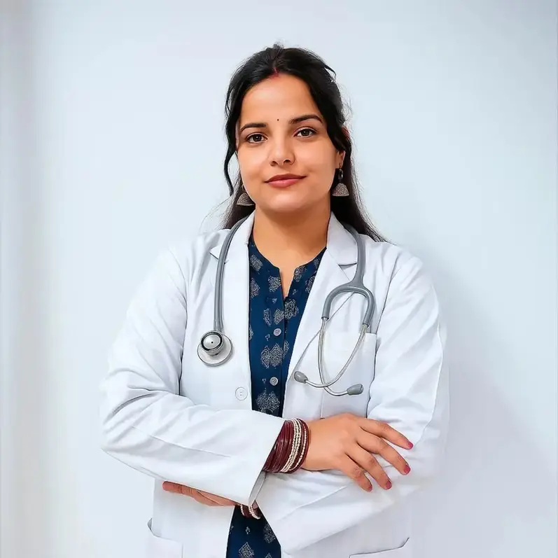 	Young female doctor Nancy Sharma in white coat with stethoscope, arms crossed, looking professional.