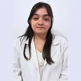 Portrait of Dr. Uttirna, a medical professional wearing a white lab coat, smiling gently.