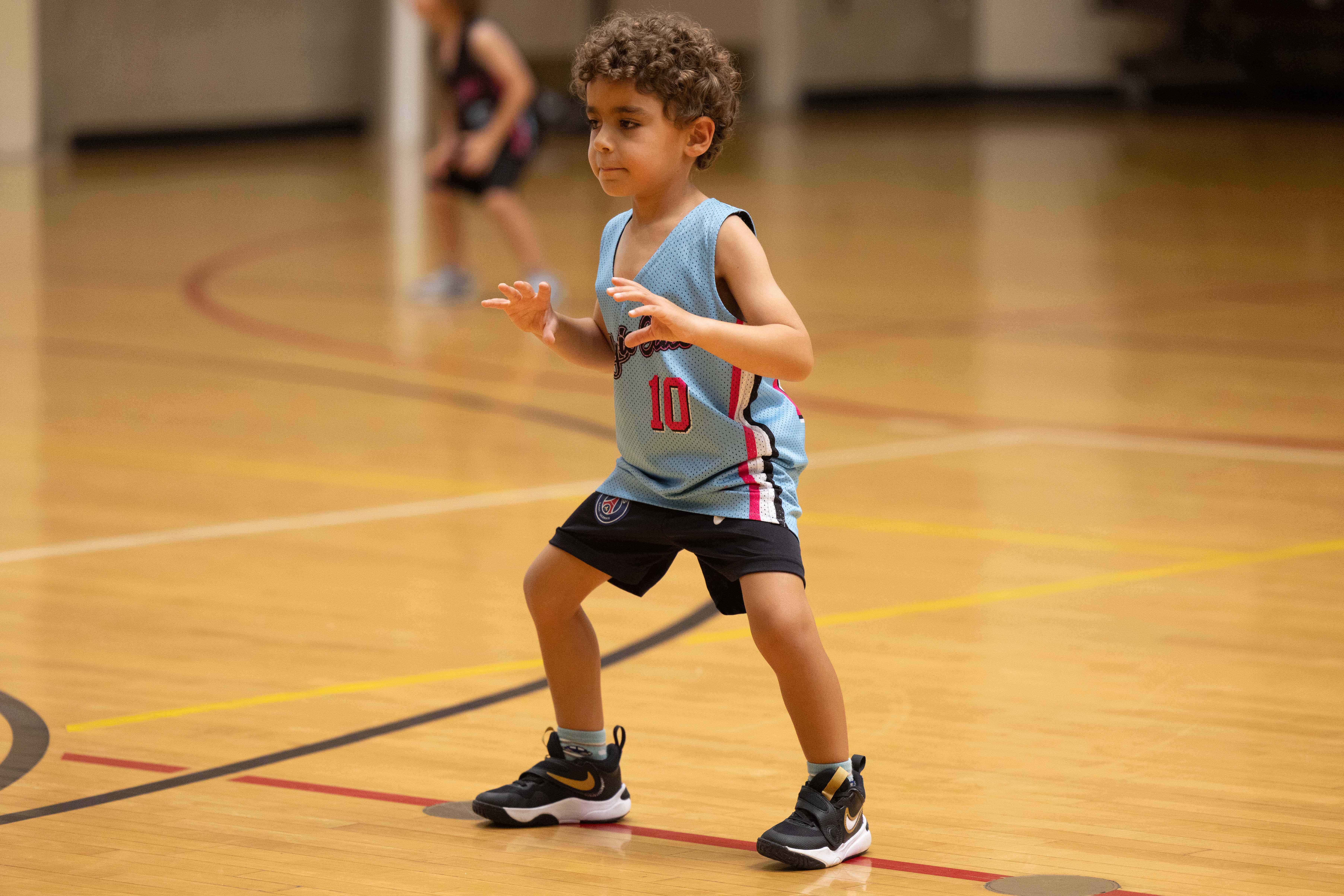 A young child doing basketball training