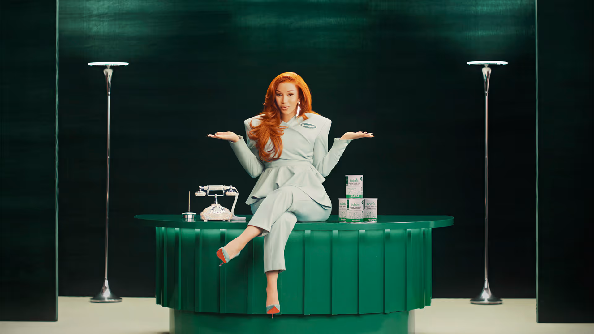 Cardi B sitting on a desk