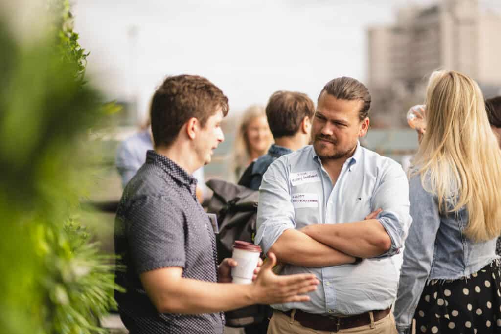Two men talking at the Babel PR UpOntheRoof Party 2023