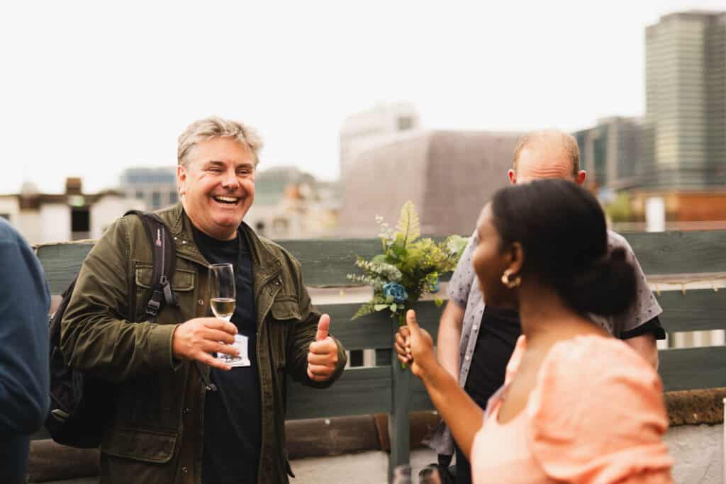 Two people giving each other a thumbs up at the Babel PR UpOntheRoof Party 2023