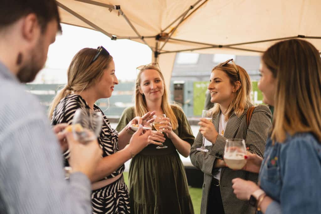 People talking under a shelter at the Babel PR UpOntheRoof Party 2023