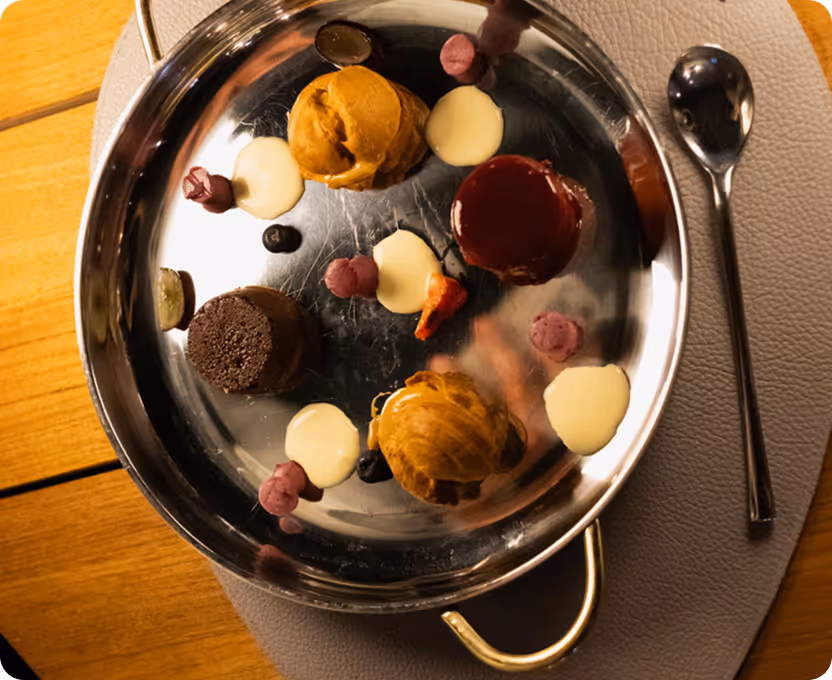 A silver plate topped with desserts on top of a wooden table.
