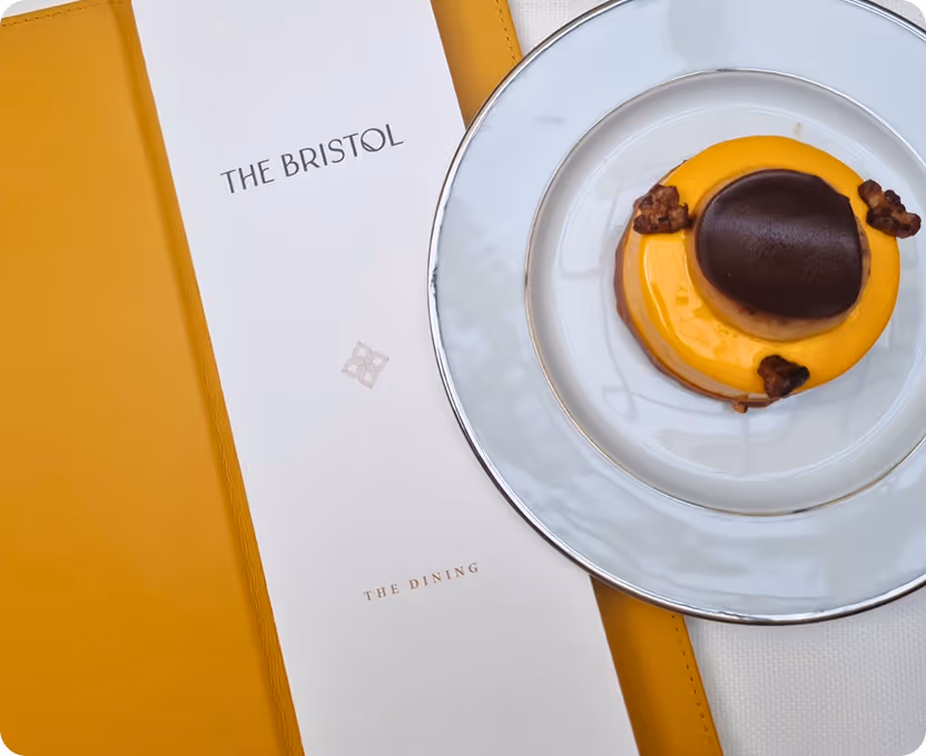 A plate with a dessert on it next to a menu.