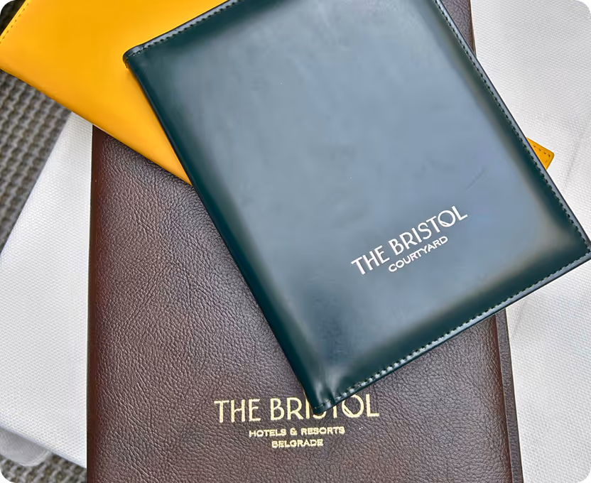 The bristo book is sitting on top of a pile of folded papers.