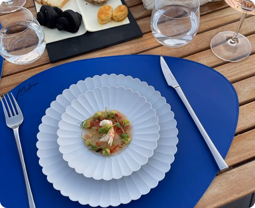A white plate topped with a salad on top of a blue table.