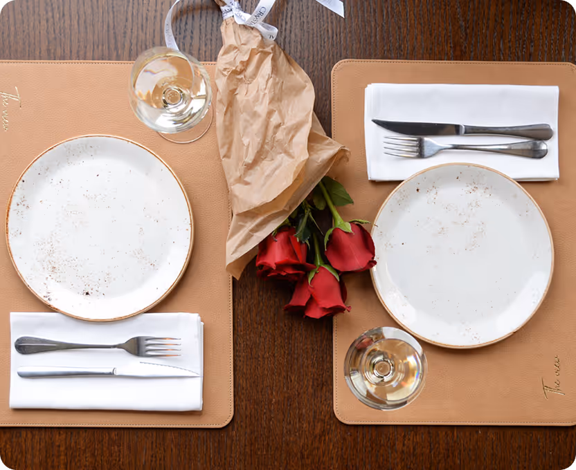 A place setting with a rose and a glass of wine.