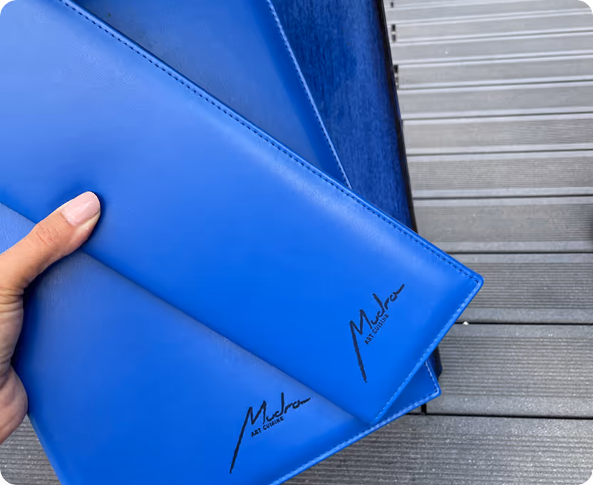 A person holding a blue folder in their hand.