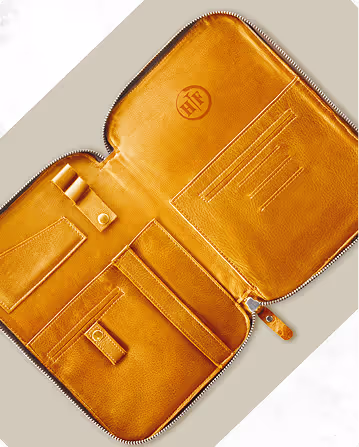 A brown leather case with a zipper on the inside of it.