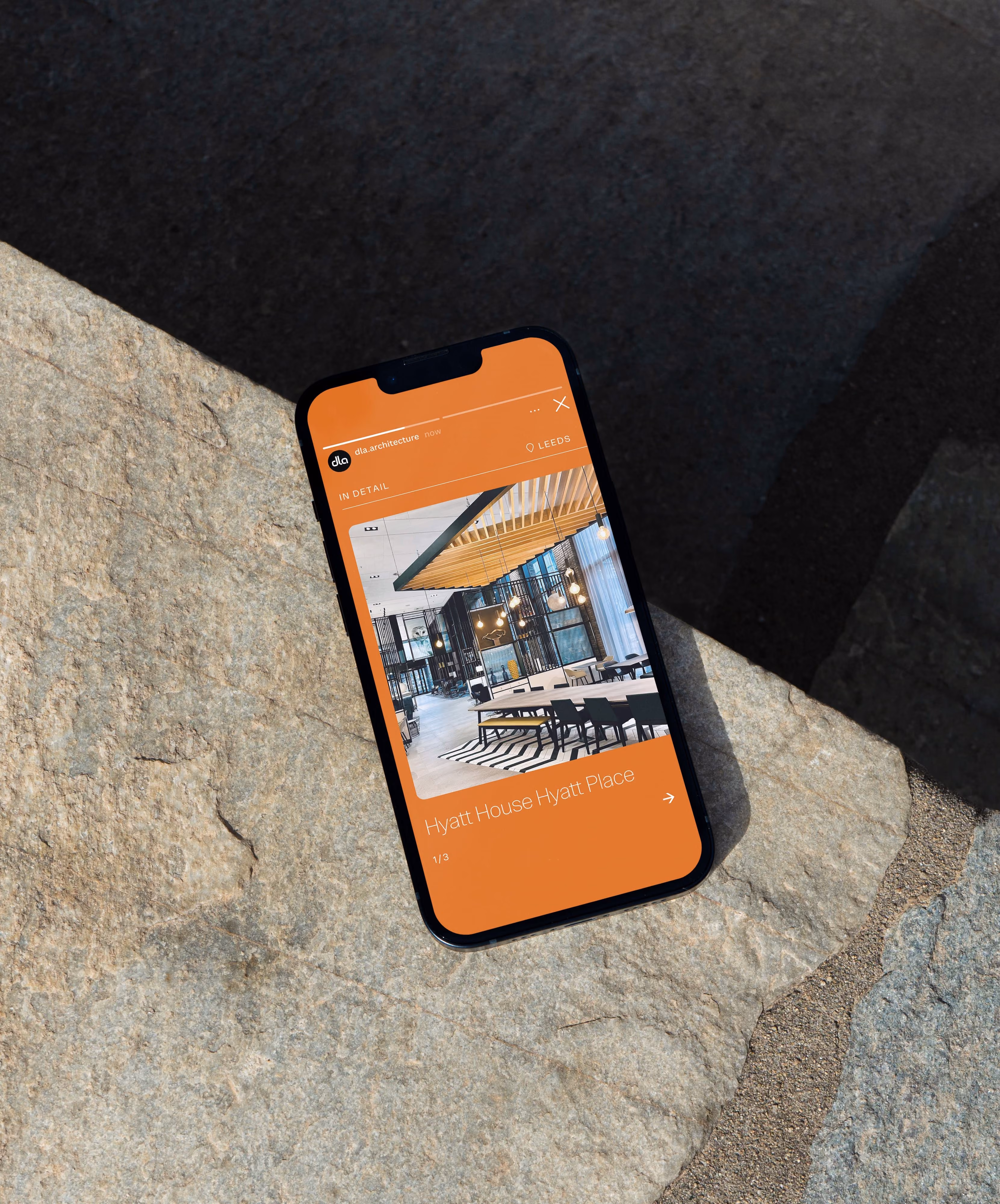 Smartphone on stone surface showing an architectural design of Hyatt House Hyatt Place interior.
