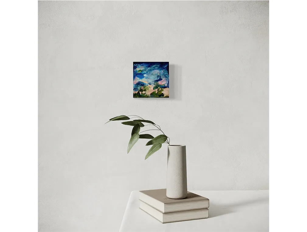 Light textured wall with a small abstract painting titled "Remember Alone" above a table with books and a vase of leaves.