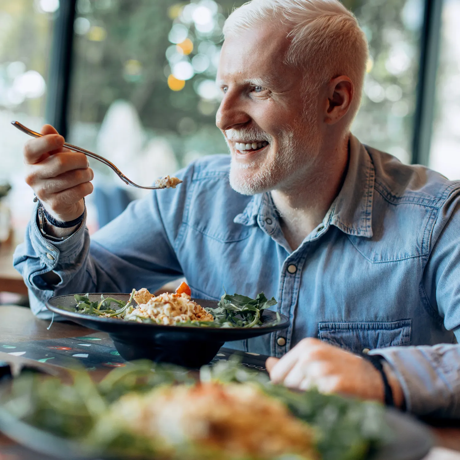 Älterer Mann genießt ein Essen im Restaurant – steht für den steuerfreien Essenszuschuss bis 112,50 € pro Monat.