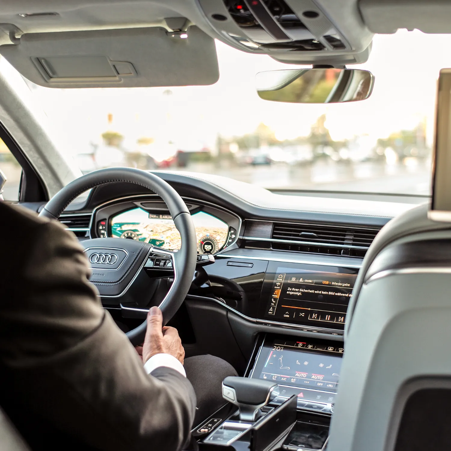 Fahrer am Steuer mit Blick aufs Navi – steht für den steuerfreien Fahrtkostenzuschuss von 0,30 €/km bzw. 0,38 €/km für Pendler.