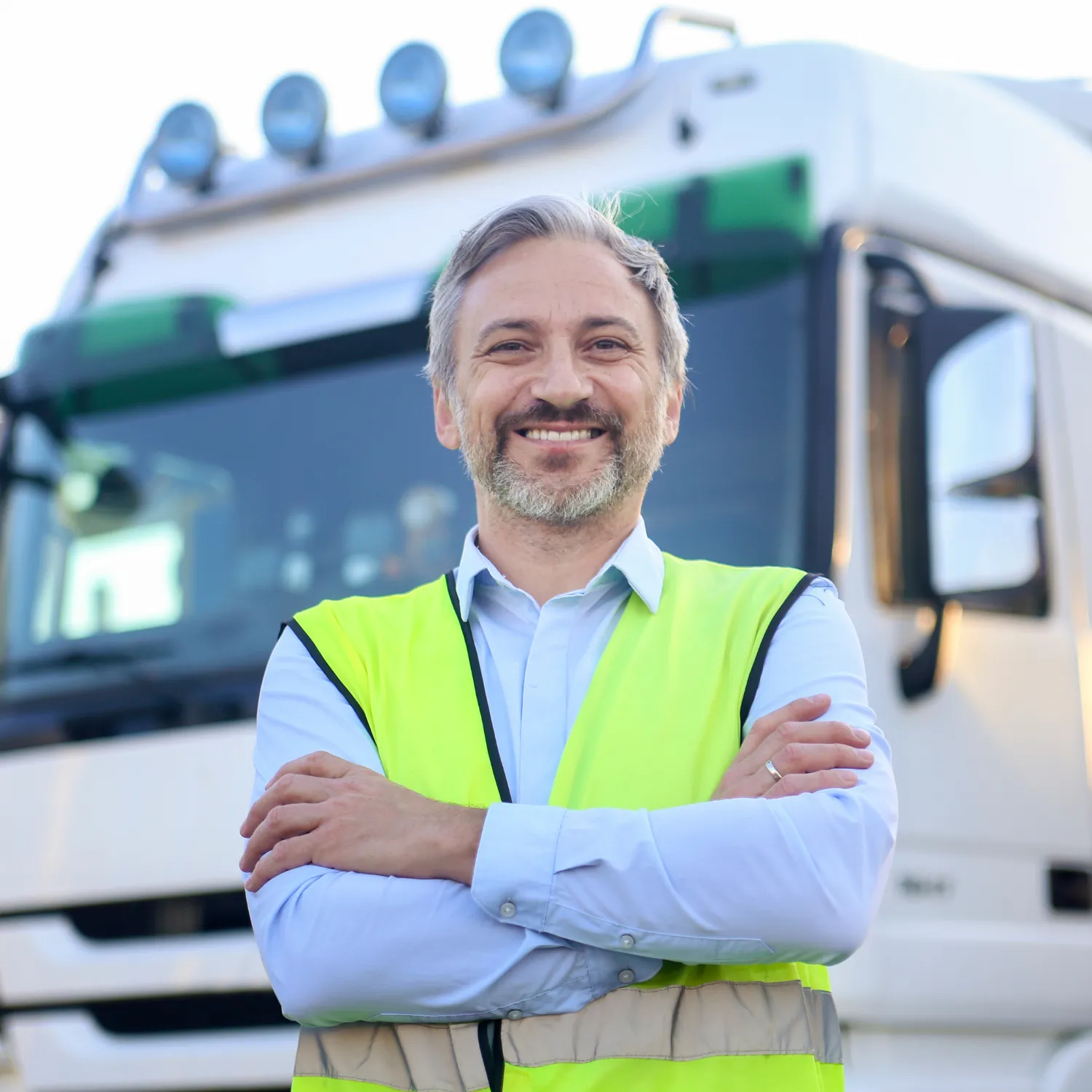 Lächelnder LKW-Fahrer vor seinem Fahrzeug – Darstellung der steuerfreien 9 €-Pauschale pro Nacht bei Übernachtung im LKW.
