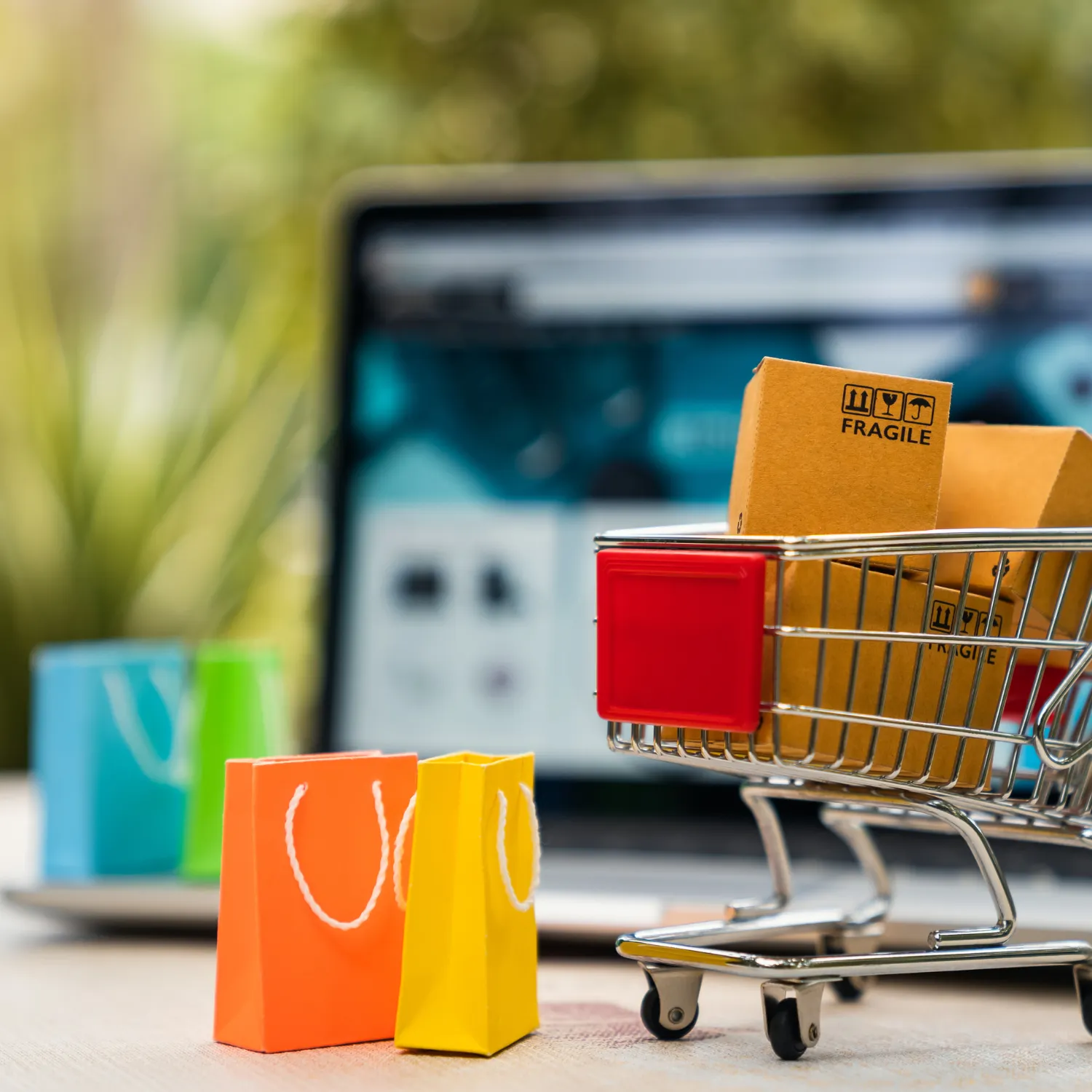 Miniatur-Einkaufswagen vor Laptop mit Paketen – zeigt die exklusiven Einkaufsrabatte und Vorteilskonditionen für Mitarbeitende als steuerfreies Zusatzangebot.