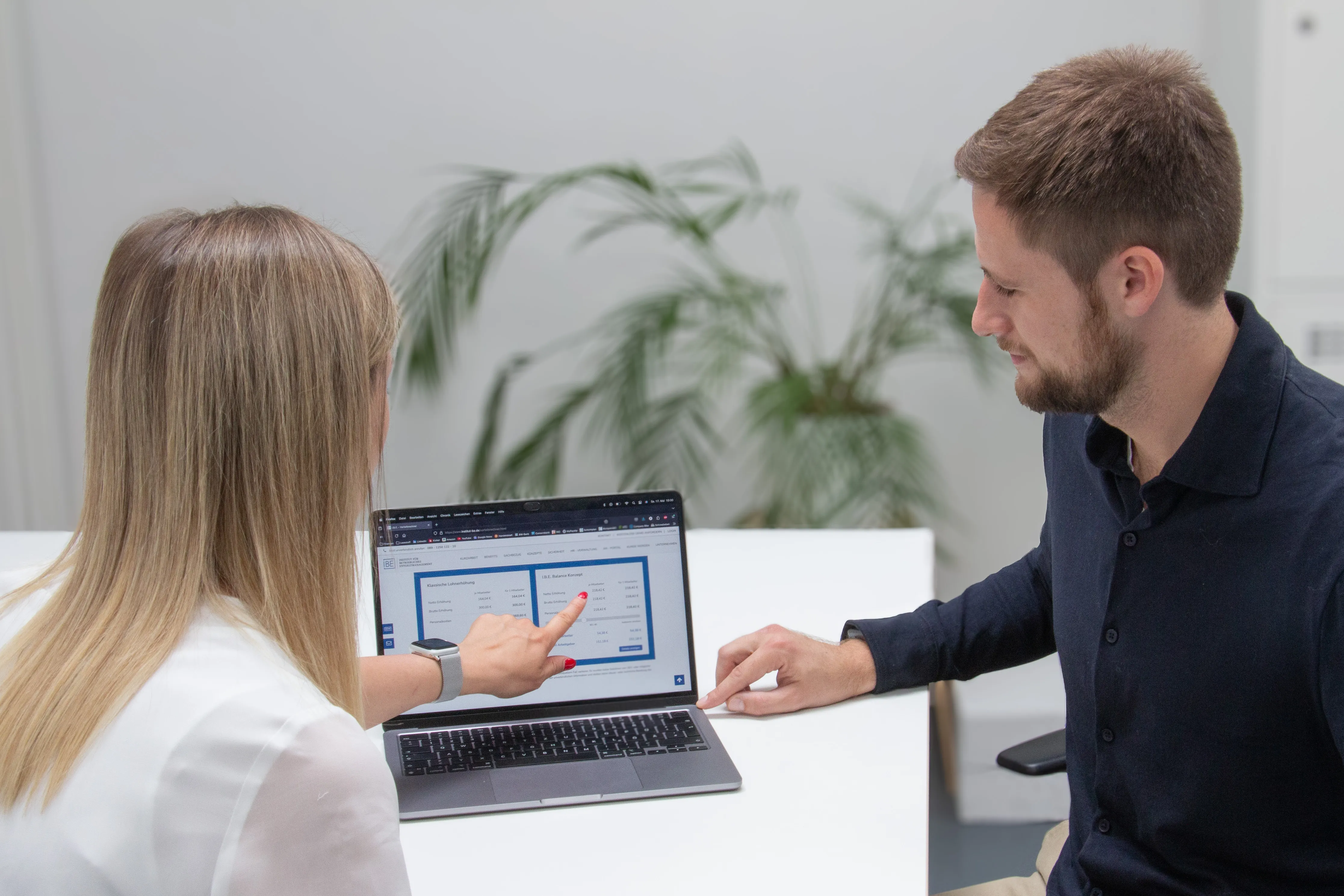 Frau zeigt auf eine digitale Anwendung am Laptop – symbolisiert den Einsatz moderner HR-Software zur Stärkung der Arbeitgeberattraktivität.
