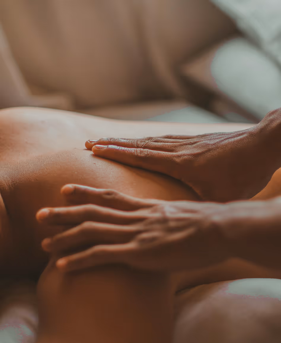Handen die een rugmassage geven op een persoon.