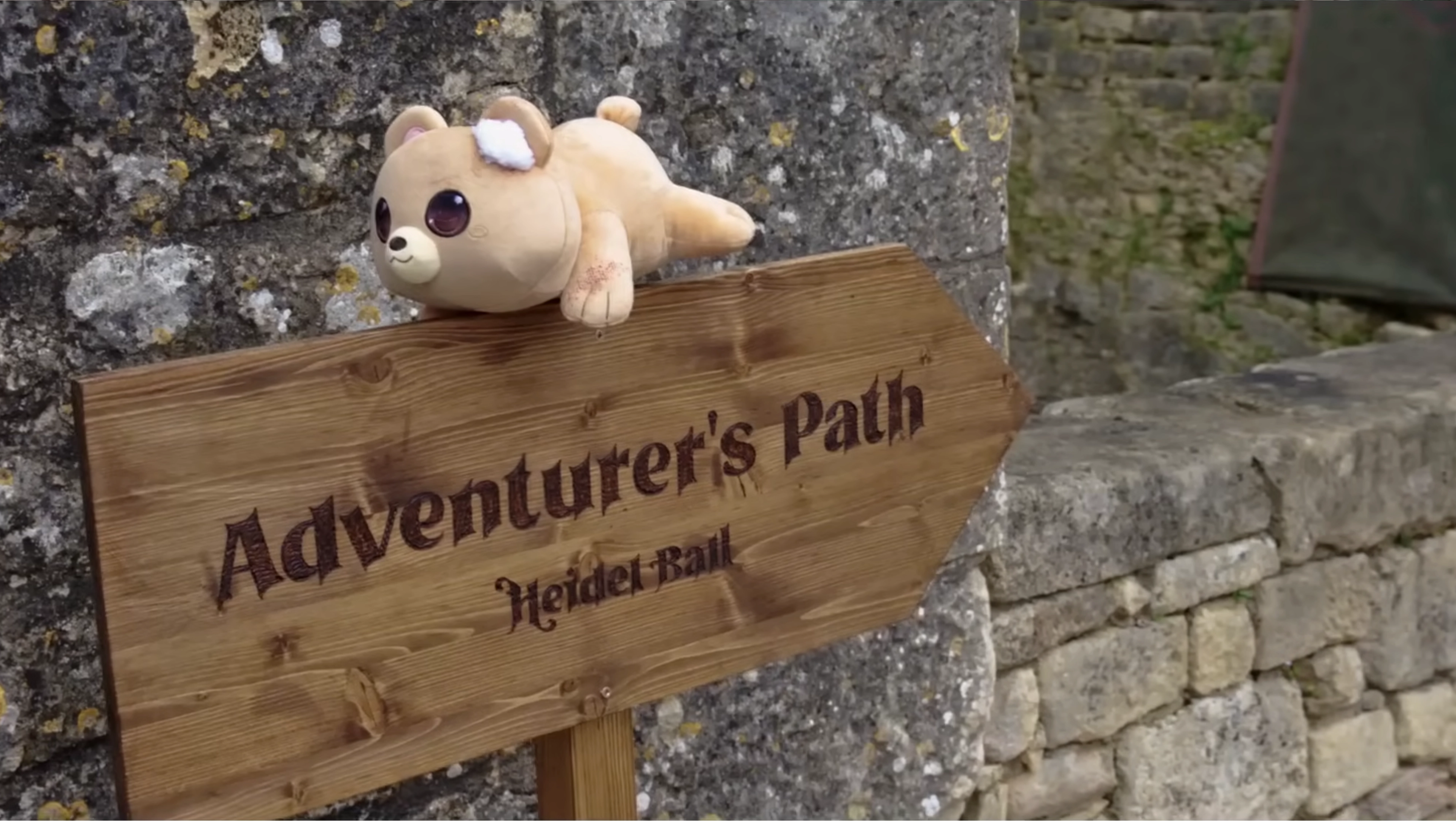 Image showcasing a scene from a video shoot through the lens of a camera. Two women and one man are looking at a magazine on the table, while the rest of the image is blurred