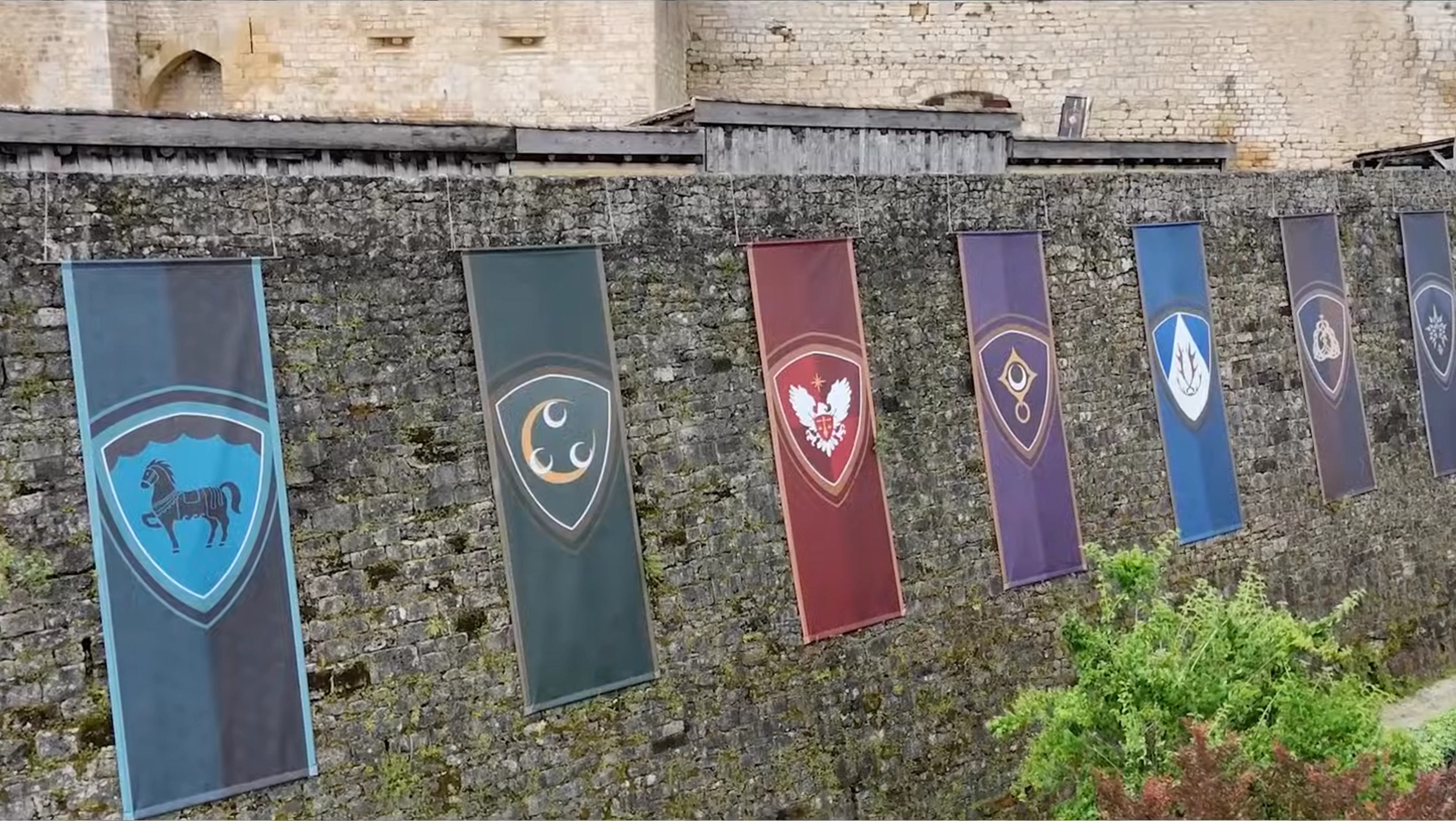Image showcasing a scene from a video shoot through the lens of a camera. Two women and one man are looking at a magazine on the table, while the rest of the image is blurred
